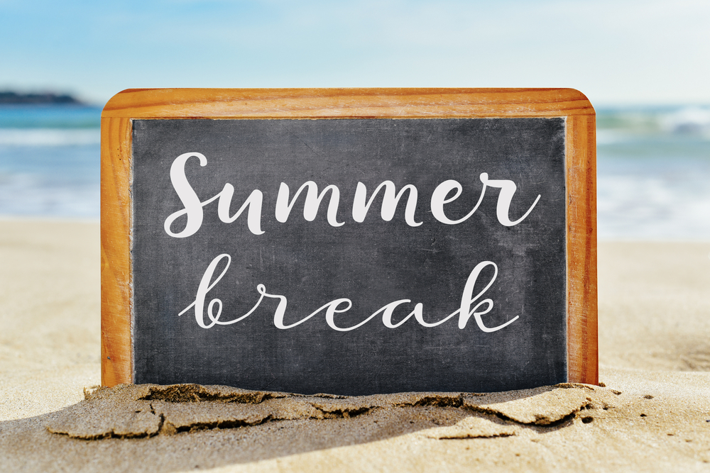chalkboard on the beach with the words "summer break" on it