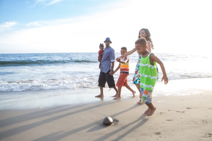 family walking on beach in San Diego