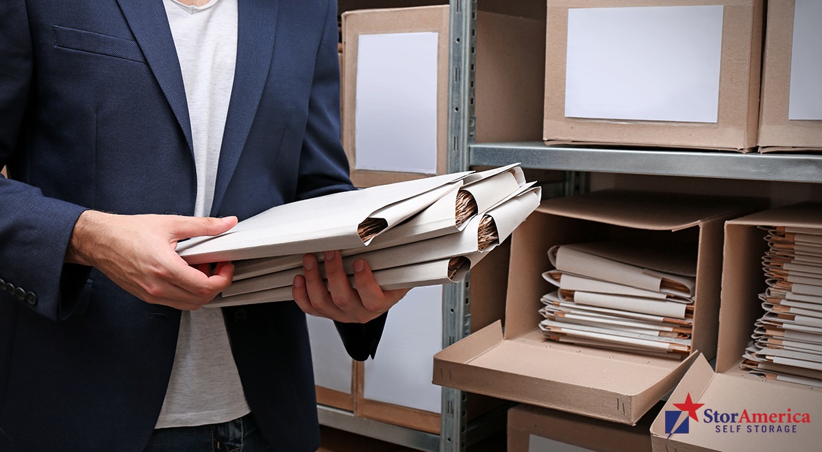 Business man putting away documents into boxes